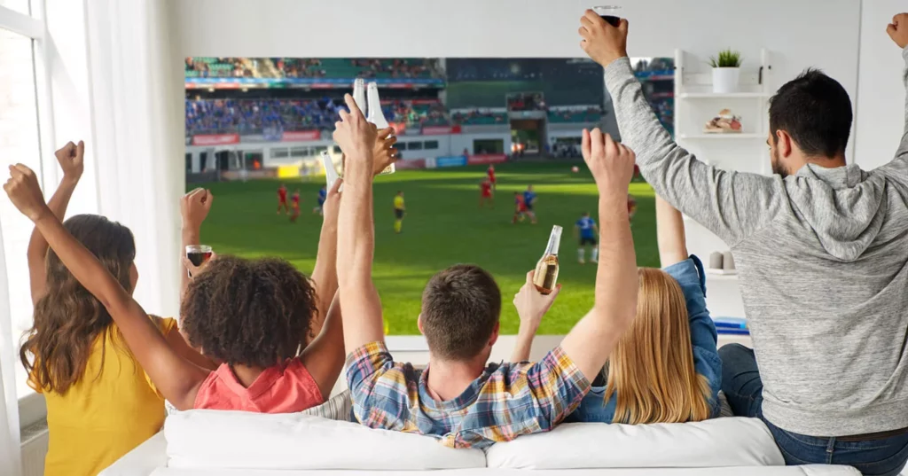 Family watching a live football match on television
